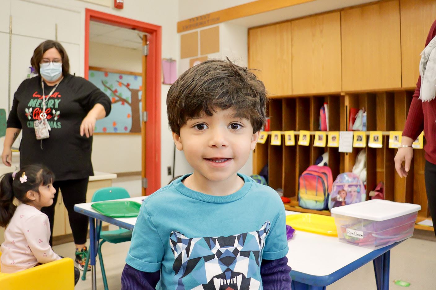 A preschool student smiles for the camera