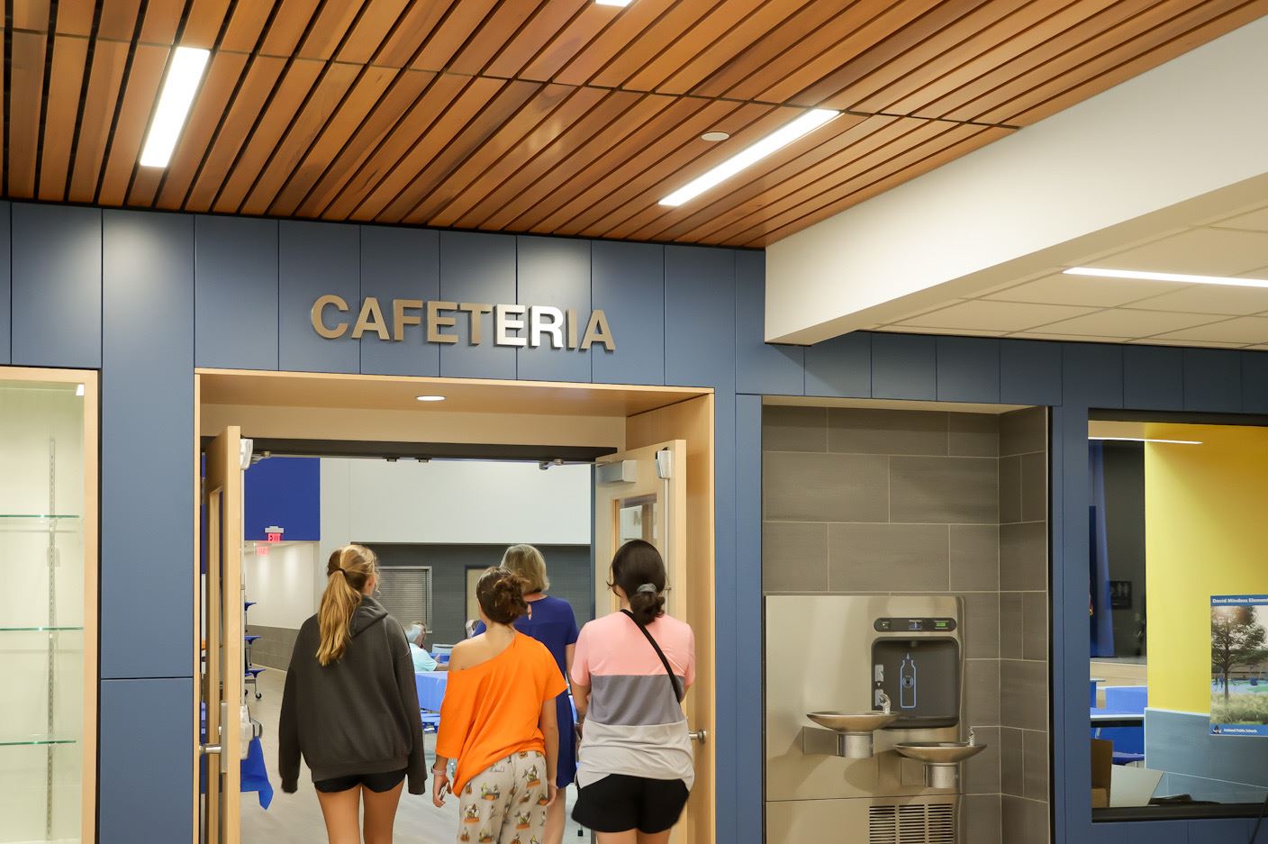 Principal Jenna Larrenaga and three students walk into the Mindess cafeteria Principal Jenna Larrenaga and three students walk into the Mindess cafeteria